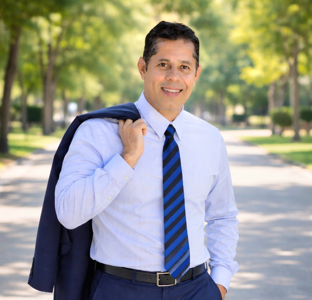 Fredy Gonzalez wearing a dress shirt and blue striped tie
